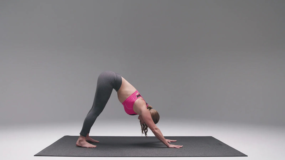 Woman in downward dog on a 6 by 4 foot mat in a grey photo studio